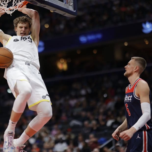 Nov 12, 2022; Washington, District of Columbia, USA; Utah Jazz forward Lauri Markkanen (23) dunks the ball as Washington Wizards center Kristaps Porzingis (6) looks on in the fourth quarter at Capital One Arena. Mandatory Credit: Geoff Burke-USA TODAY Sports